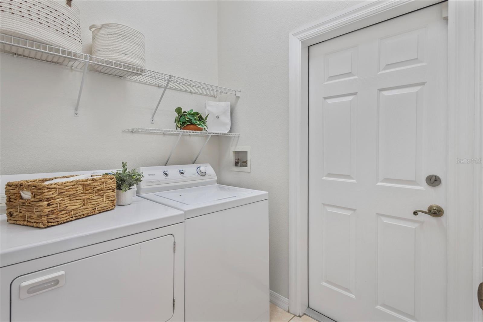 Indoor laundry room leading to 2 car garage