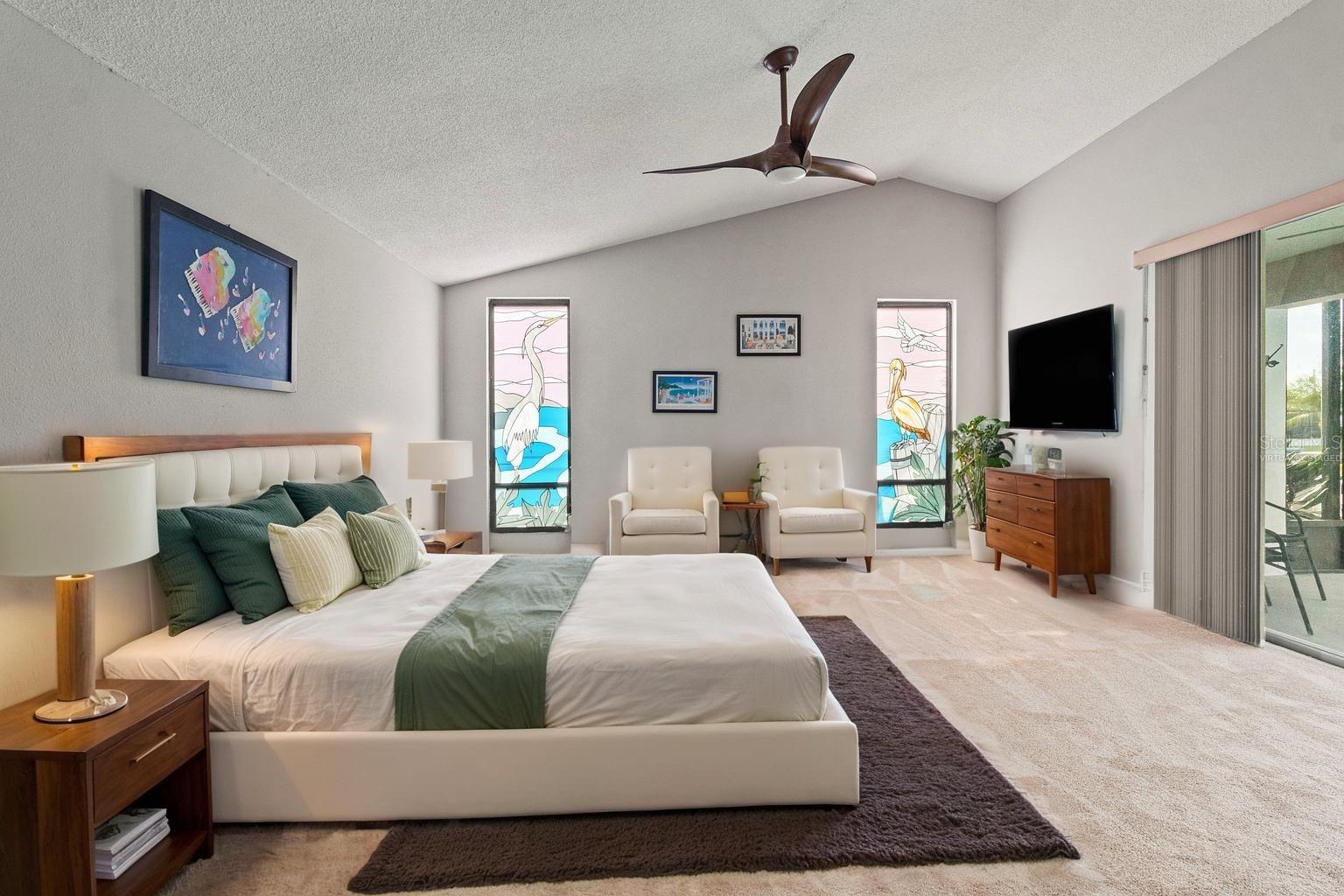 Virtually Staged Primary Bedroom With ensuite bath and sliders leading out to the pool deck