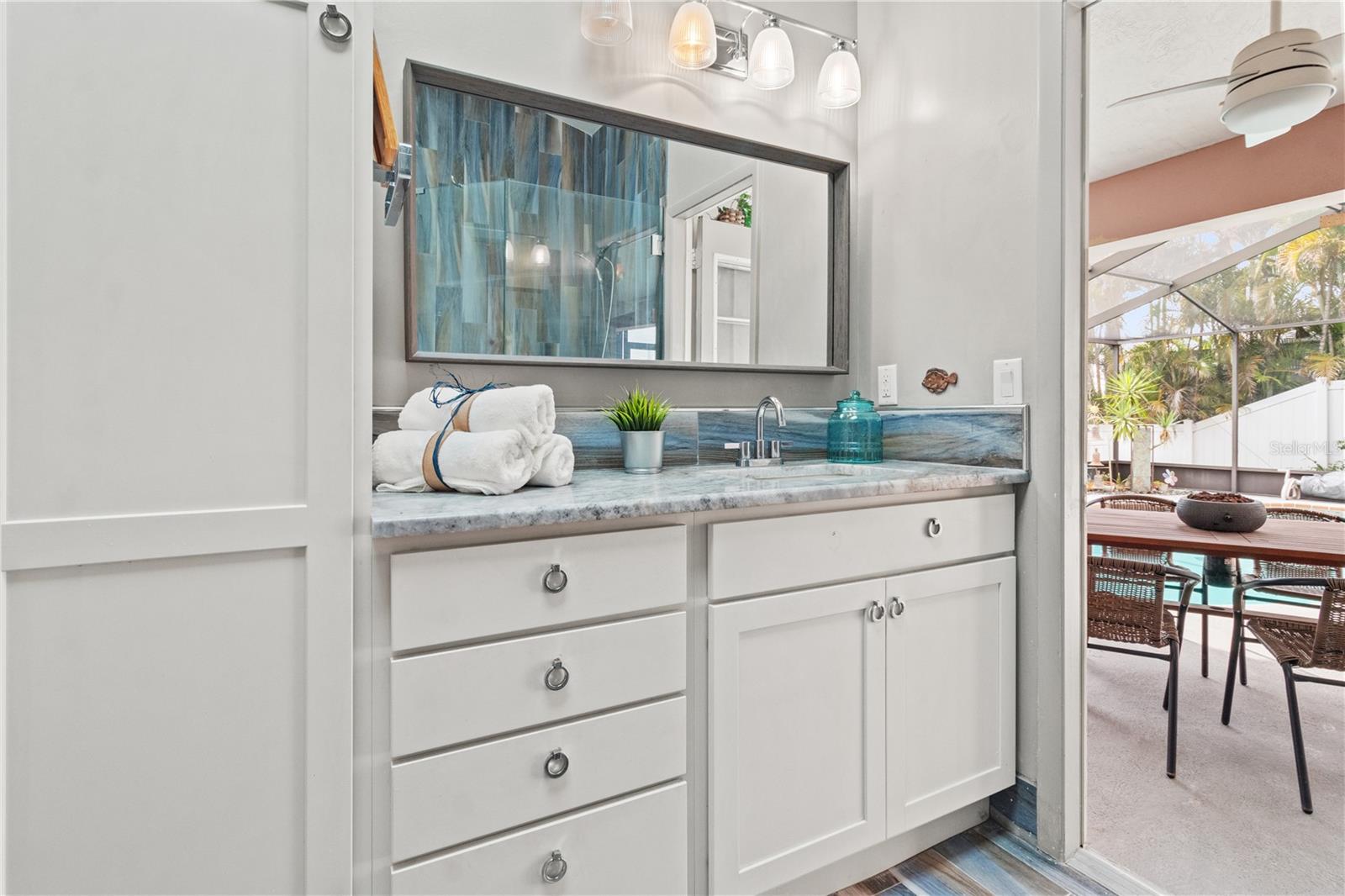 The primary suite bathroom leads directly to the pool area