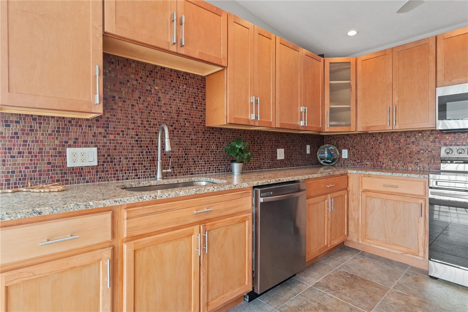 Maple cabinets, granite counter tops and an artsy backsplash