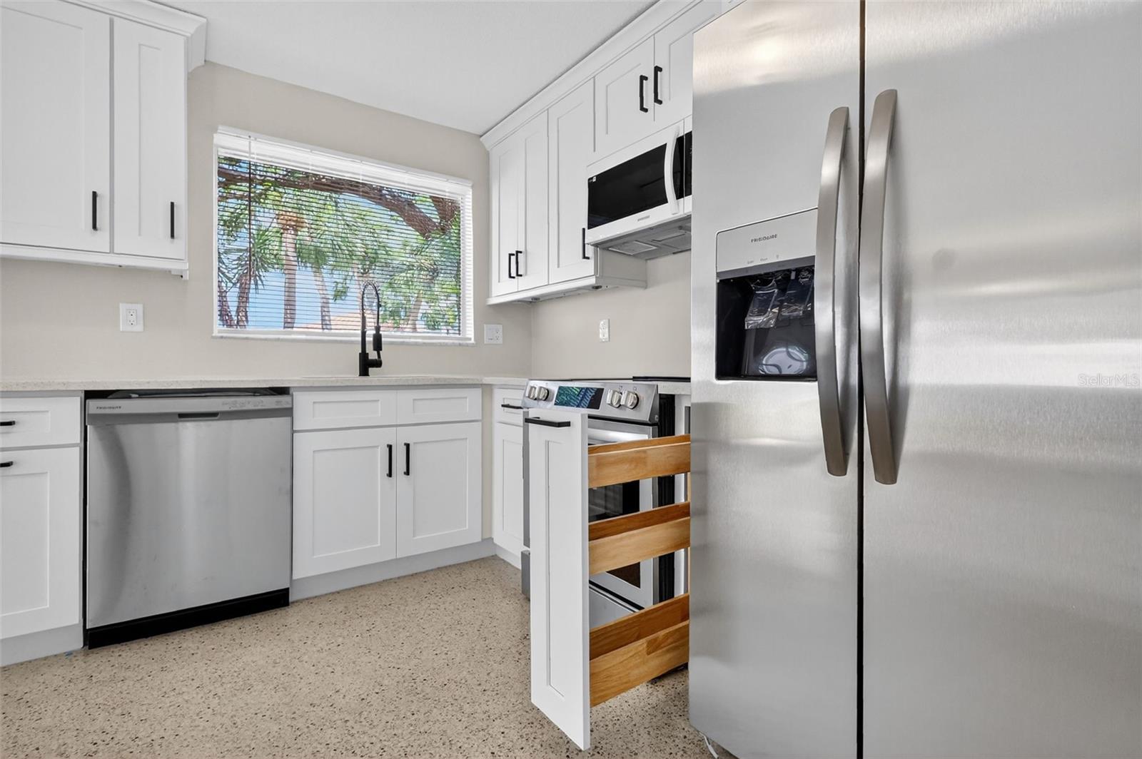Next to the stove is a convenient pull out spice and oil rack