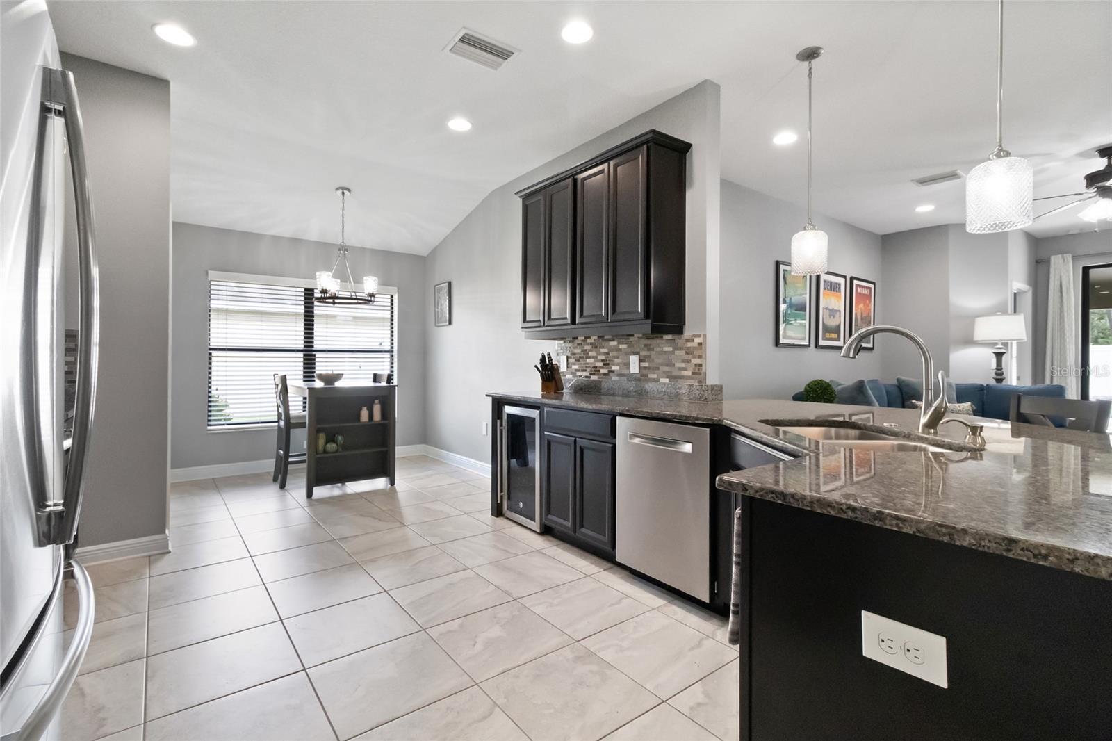 Ebony kitchen cabinets, stainless steel appliances - including refrigerator and wine cooler, granite counters and glass tile backsplash!
