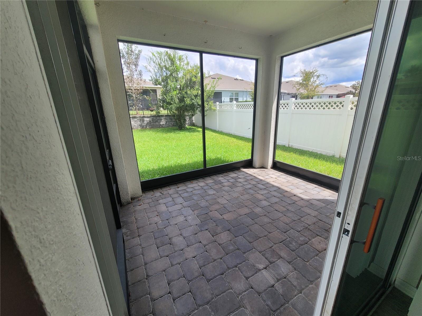 Enclosed Lanai facing fenced backyard