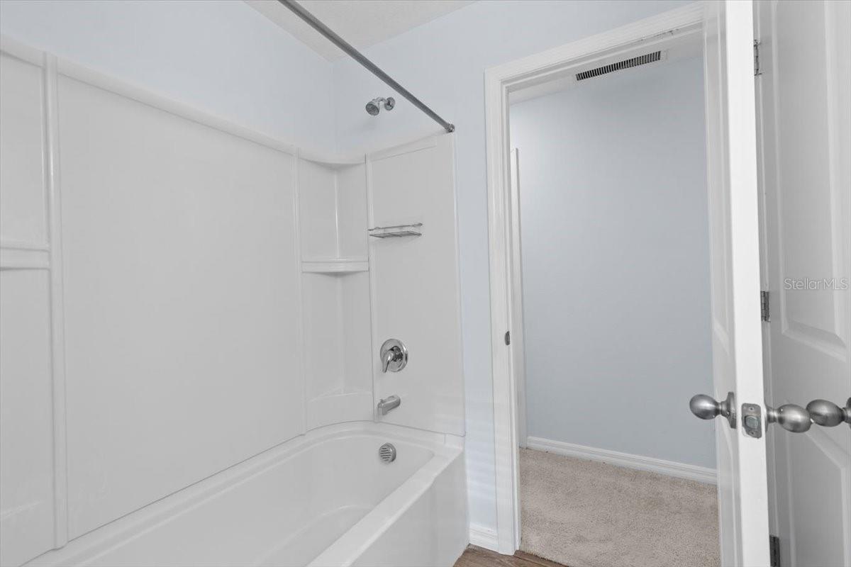Main bathroom with tub and linen closet.