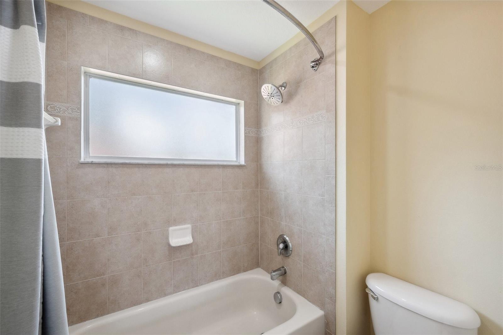 Private tub/shower & toilet area with a pocket door