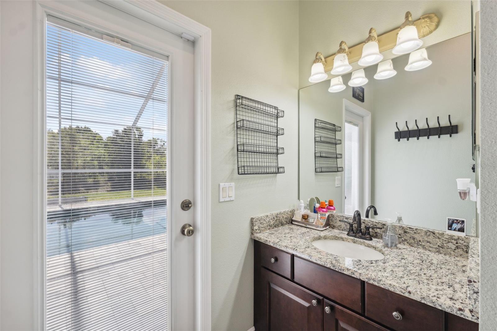 Guest bath leads to pool area.