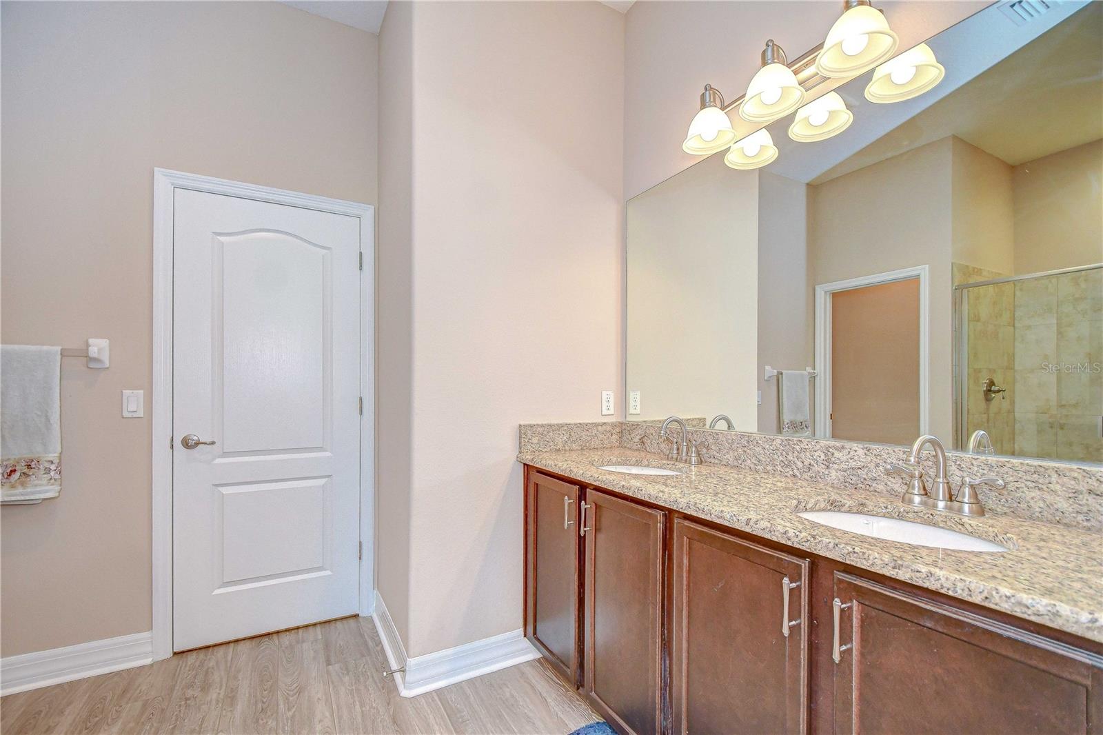 En-suite bath in first floor bedroom with dual vanities and walk-in shower.