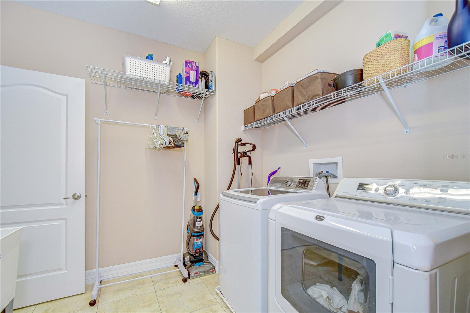 Upstairs laundry room with door to primary walk-in closet.