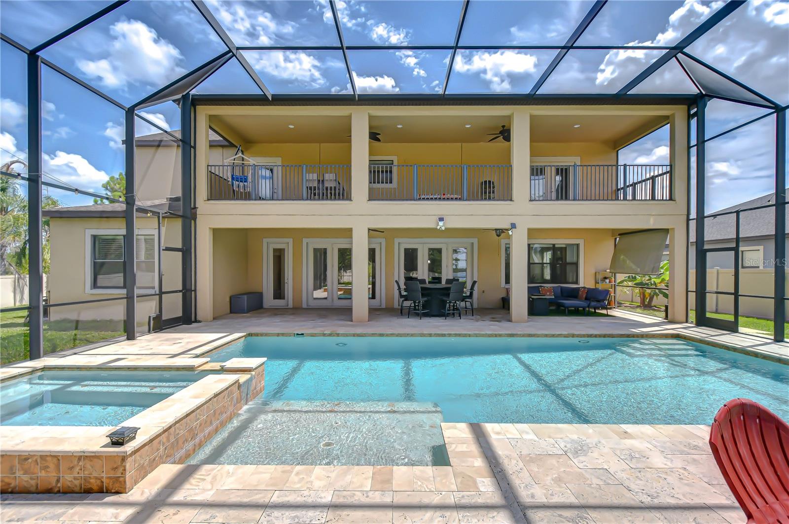 Back of home with extra large covered patio seating, both upstairs and downstairs.