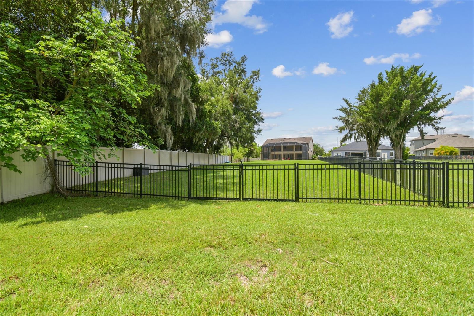 View from common ground to fully fenced in oversized back yard.