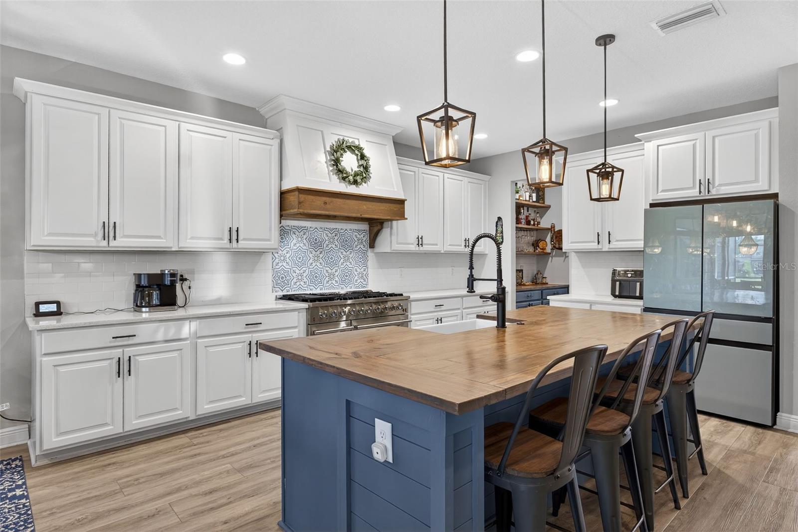 Your kitchen is upgraded with butcher block island, overhead lighting, GAS stove, built-in hood and upgraded appliances.