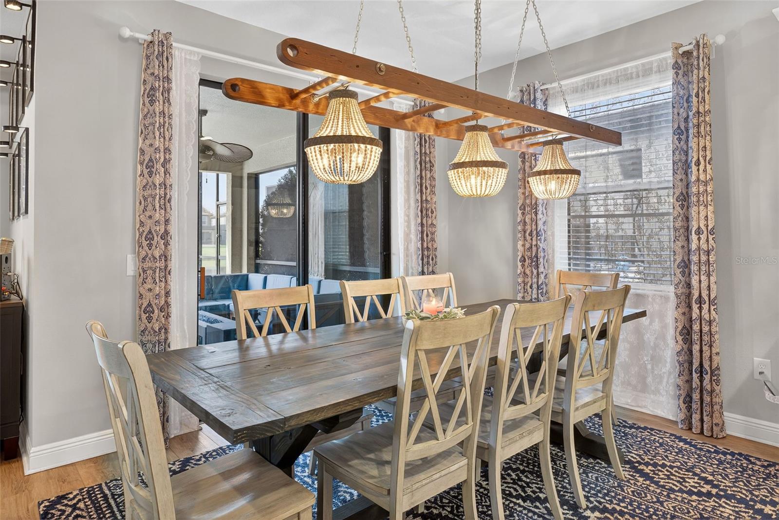 Dining room has custom built by hand overhead lighting fixture seated before the sliding glass doors to the pool area.