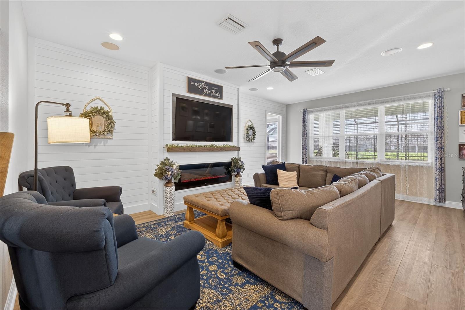Living room has electric fireplace, custom wall and mantle.