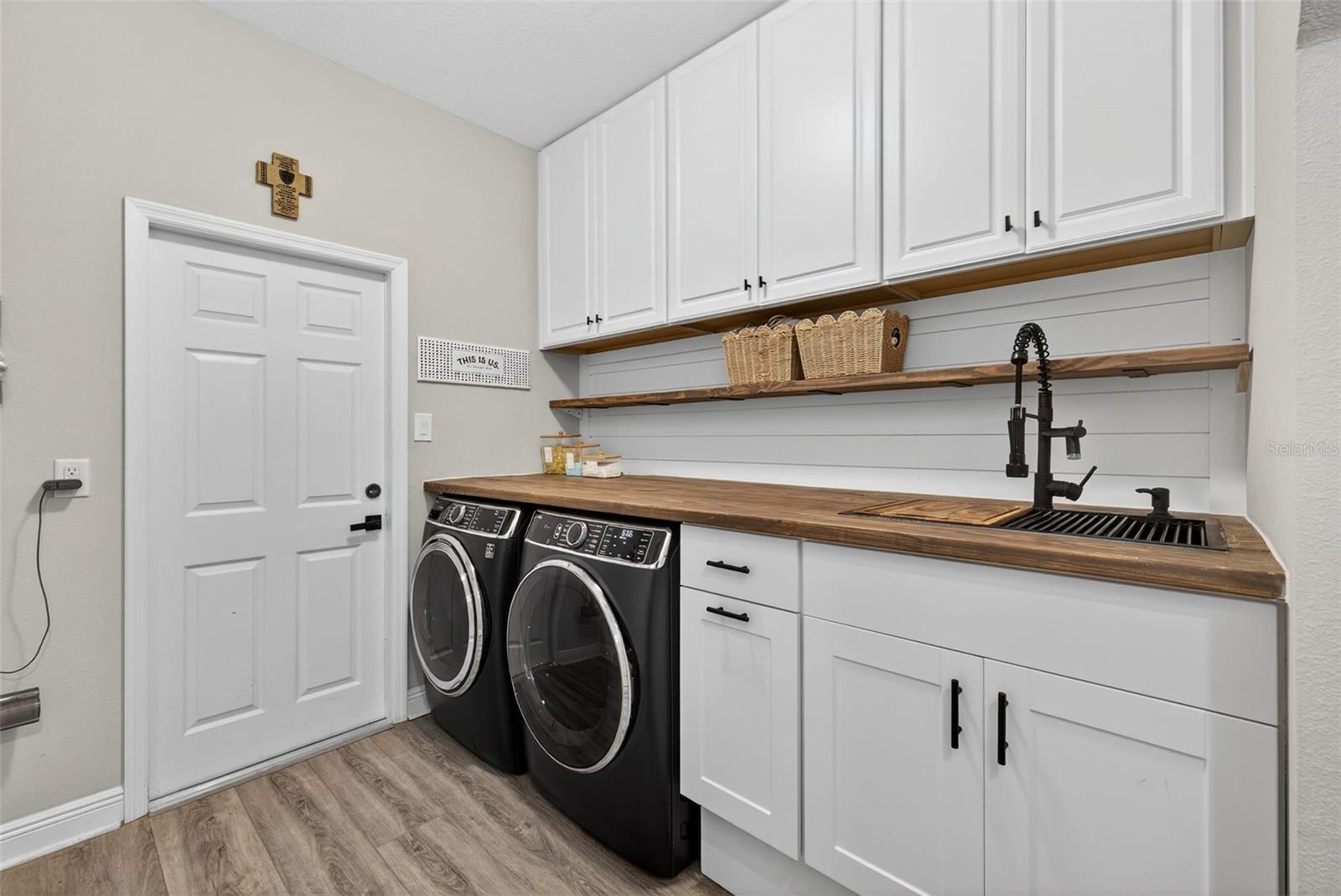 Customized built in laundry room with sink, additional cabinetry and storage