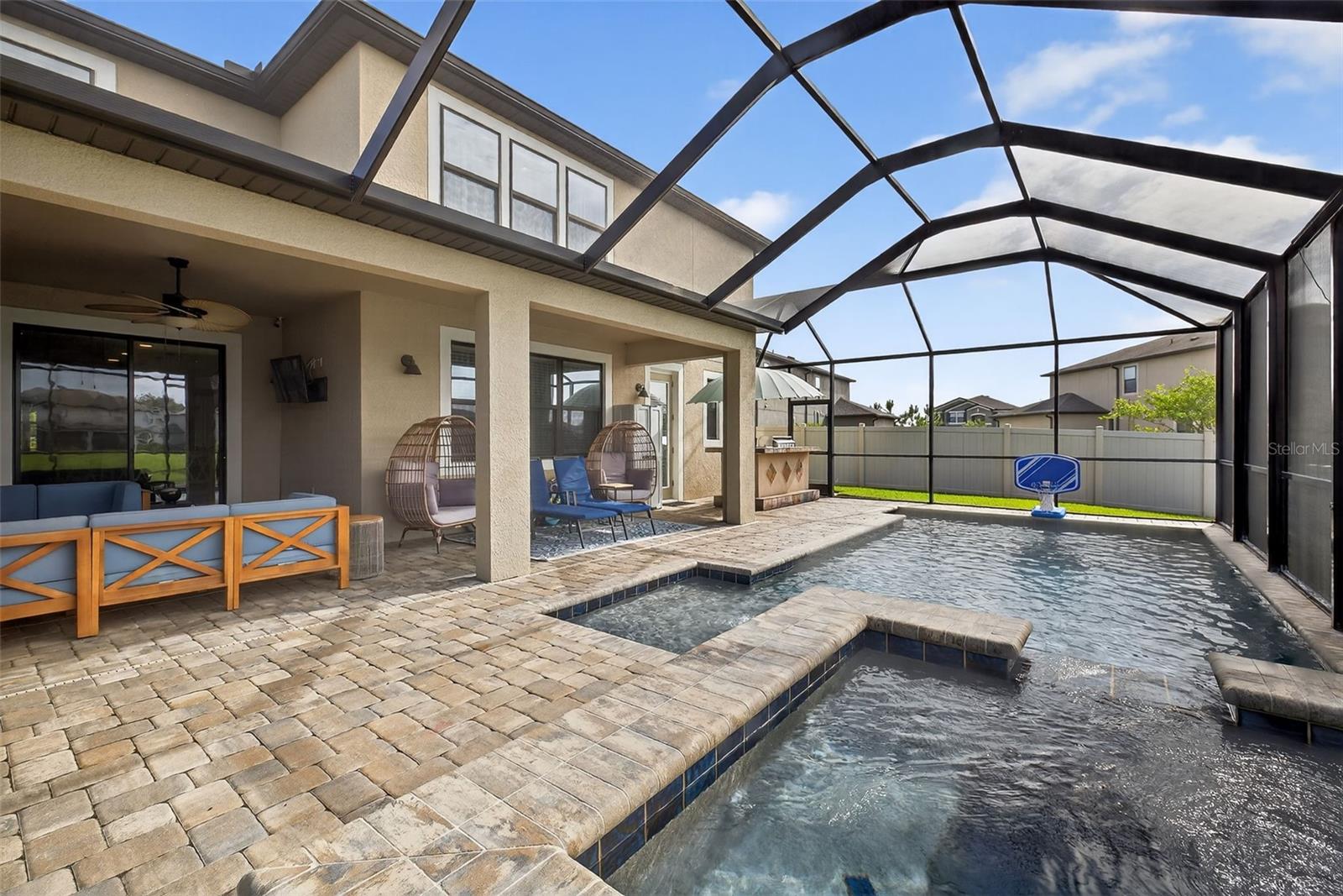 Hot tub, paver deck, projector screen on the pond side