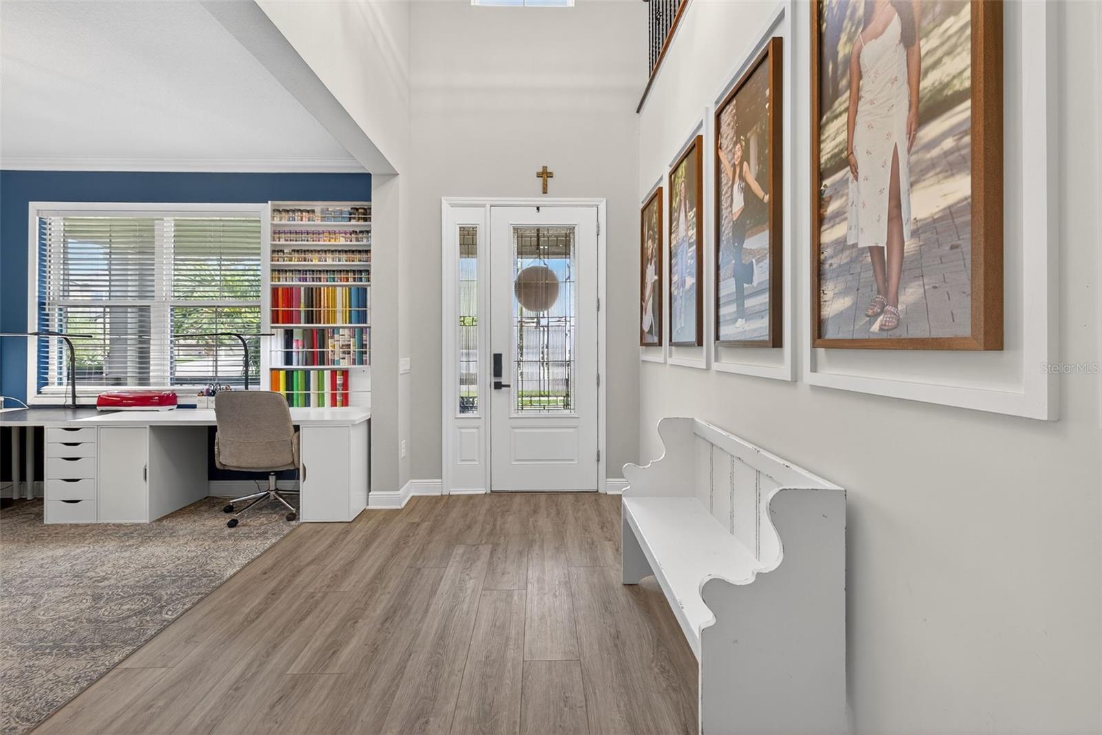 The glassfront door provides ample light and front flexroom/office space is accented with shiplap wall.