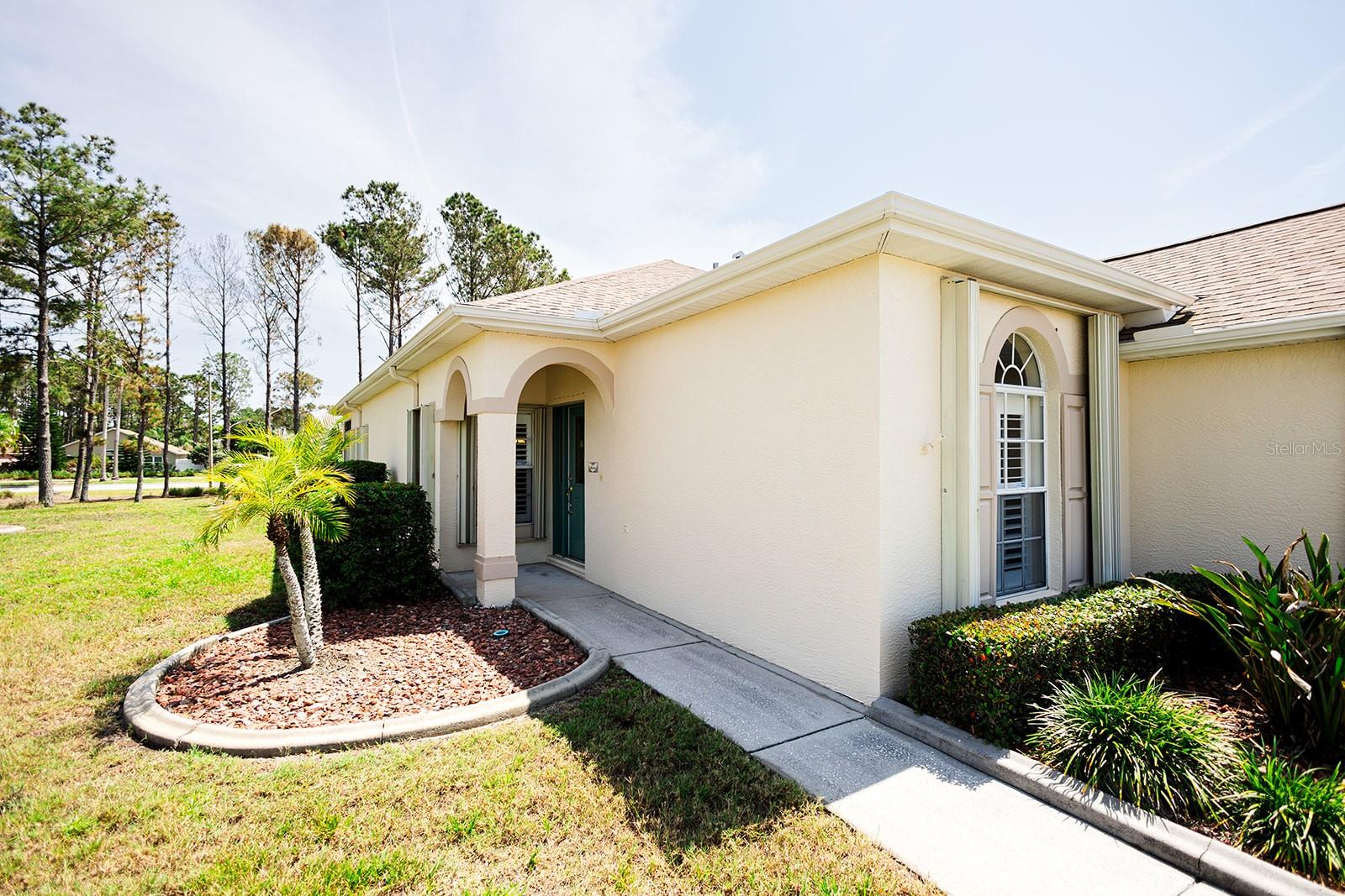 Covered entry and mature landscaping