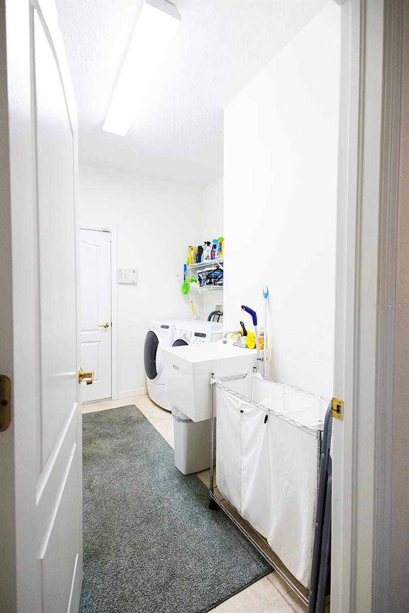 Inside laundry room with utility sink, washer & dryer as well as storage!