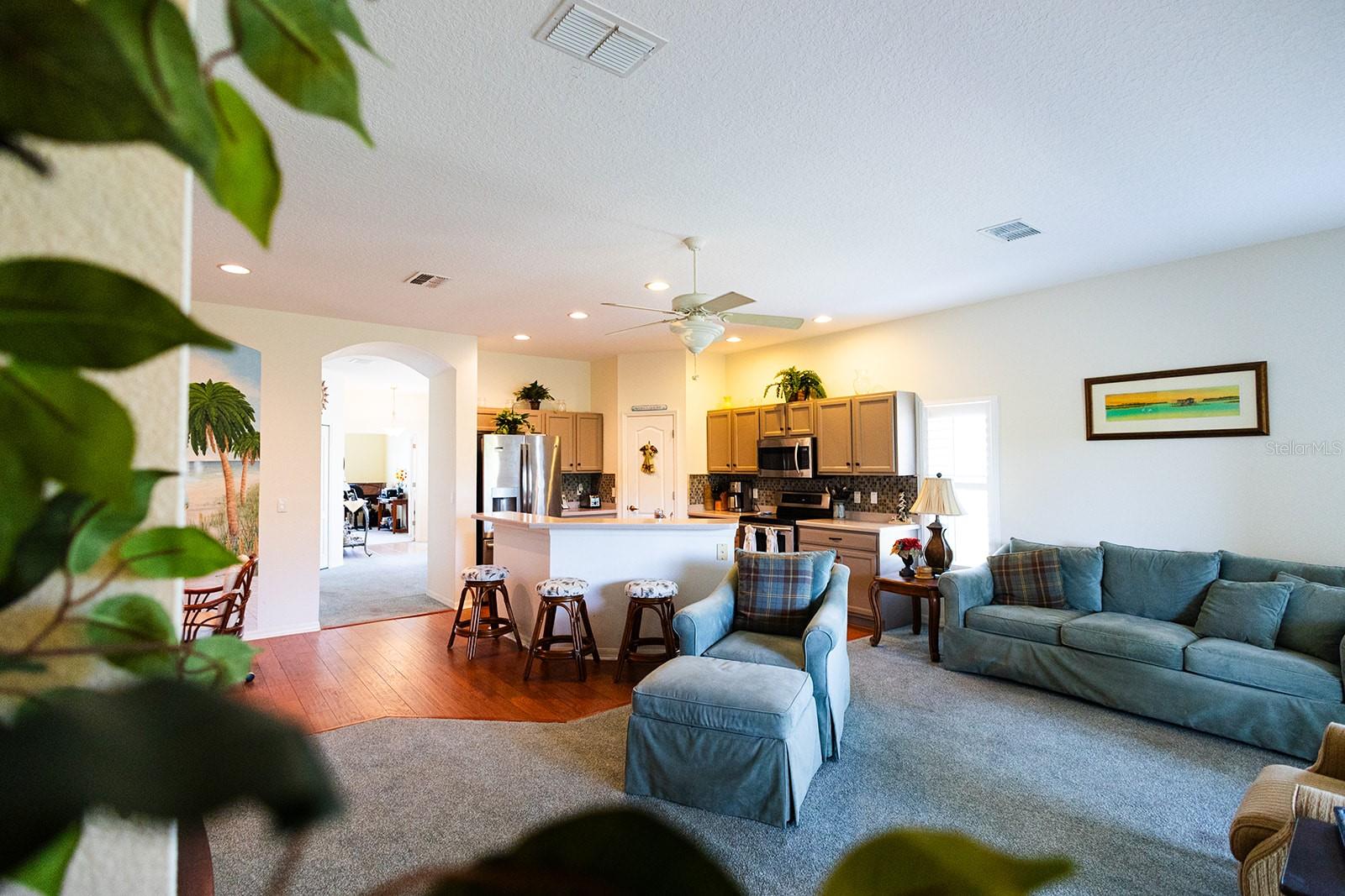 Large open living room and kitchen with breakfast bar seating.