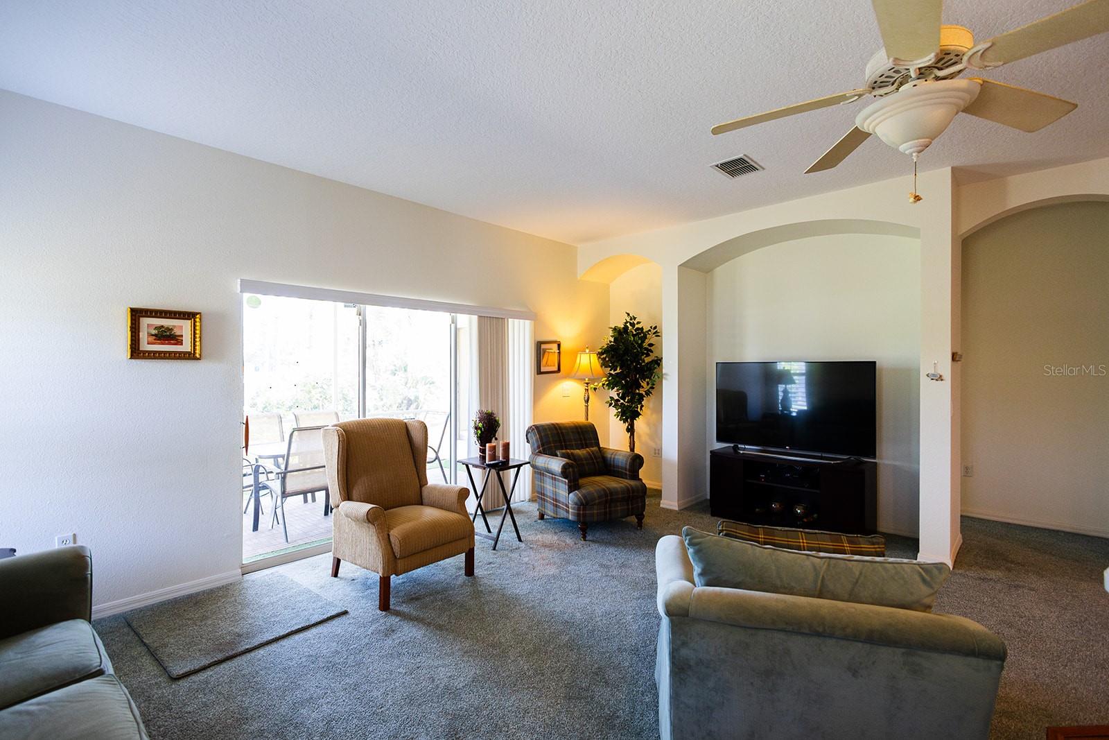 Living room with triple slider access to the beautiful screened lanai.