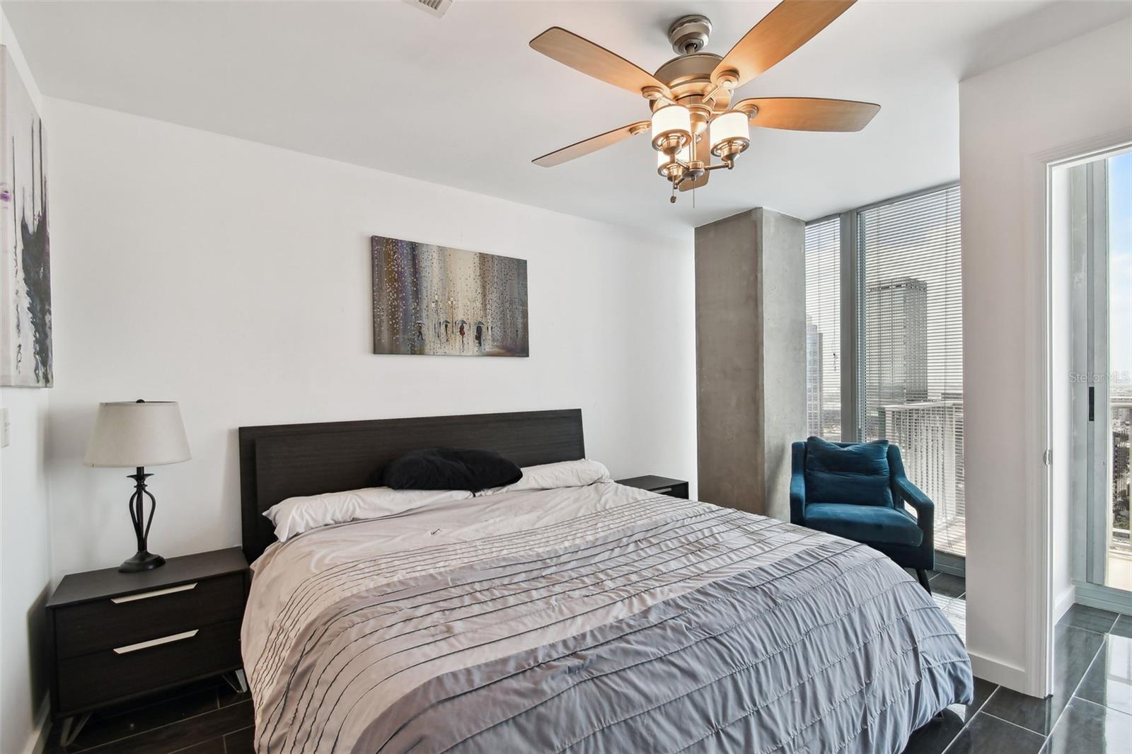 Modern finishes, a sleek ceiling fan, and a private seating nook elevate this space into your personal retreat above the city.