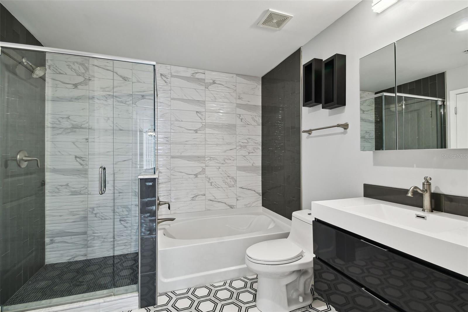 Step into spa-inspired luxury with this beautifully upgraded primary bathroom, featuring a glass-enclosed walk-in shower, separate soaking tub, dual vanity, and designer finishes throughout.