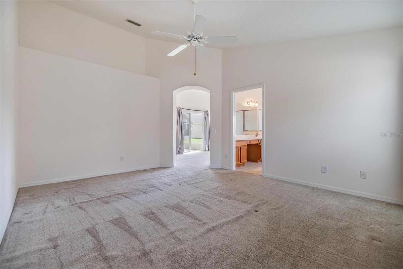 Master bedroom with arched doorway and display ledge