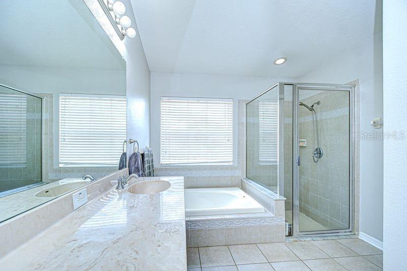 Primary Bathroom with two vanity areas, walk-in shower and soaking tub.
