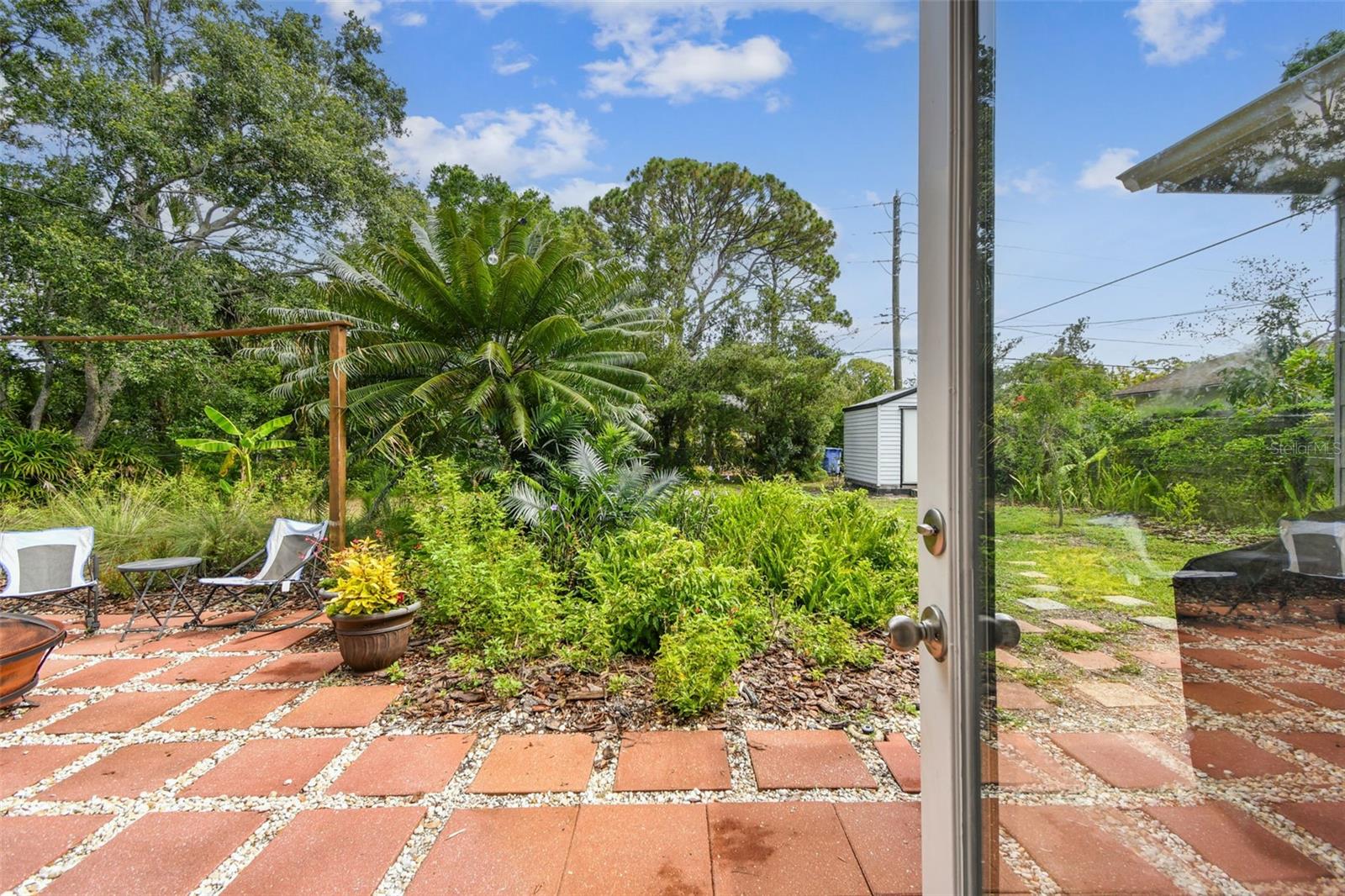 Huge pool-sized Backyard with open patio, storage shed, and chain-link fencing.