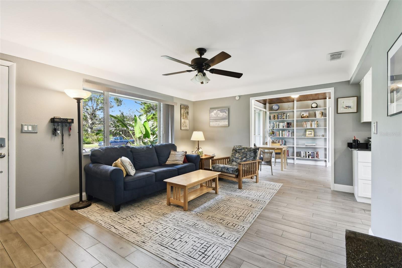 Spacious Living Room with big picture window. Coved ceilings, ceiling fans. Porcelain tile floors-lovely and durable