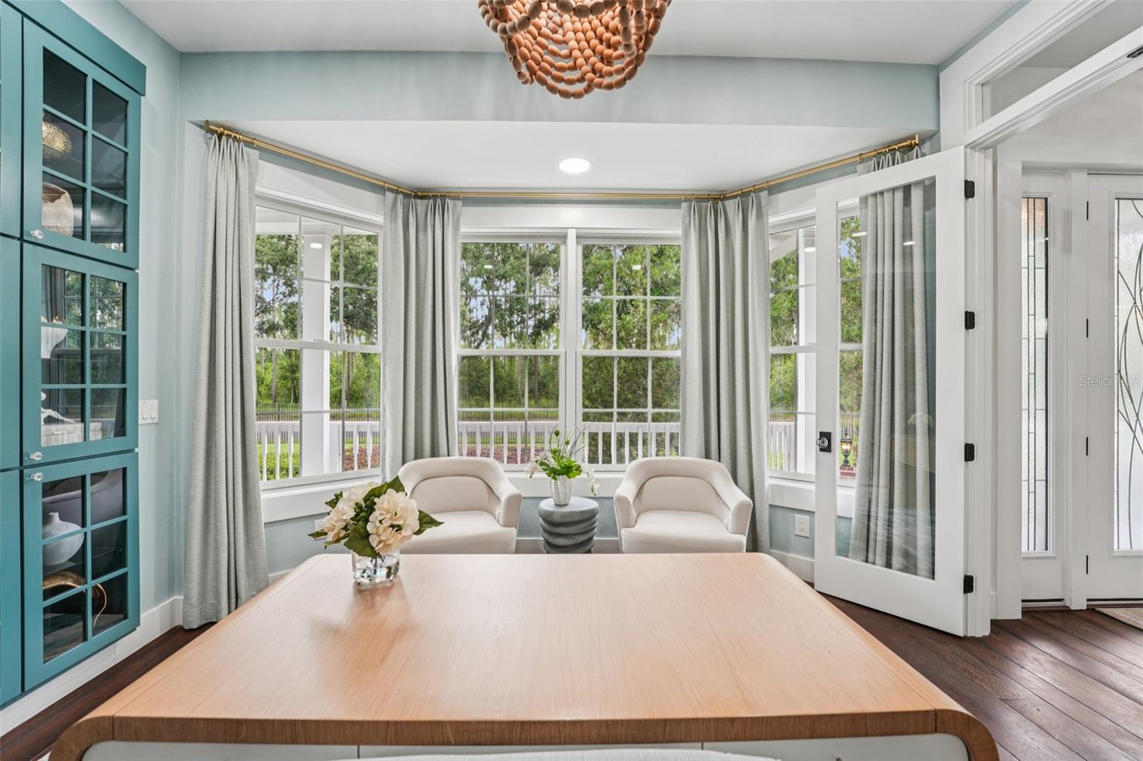 Office with built in glass display case and view of the front yard