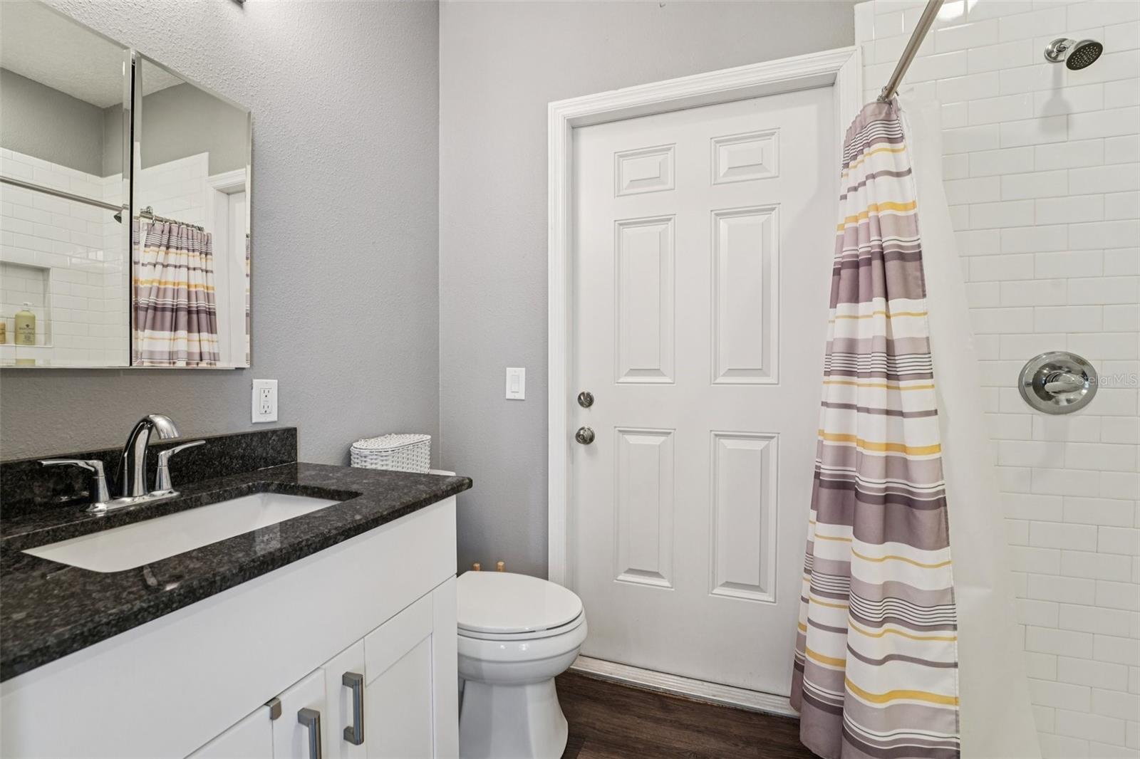 Guest house bathroom with separate exit door to outside