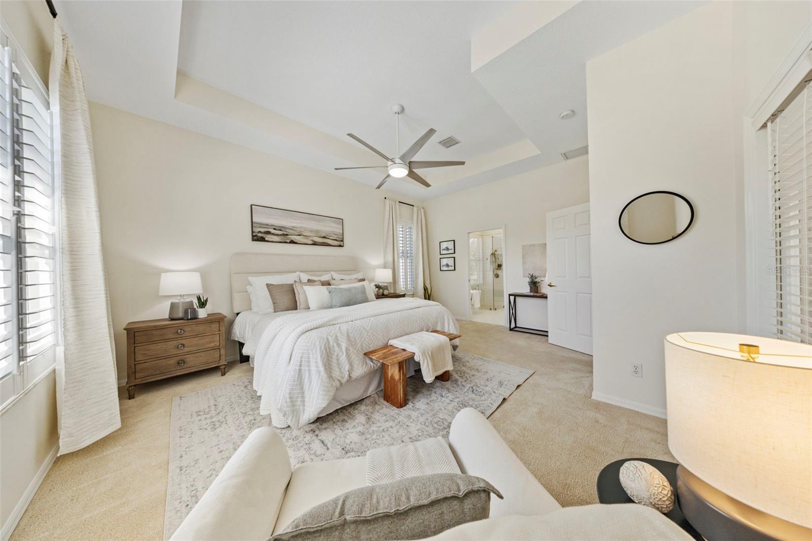 Spacious primary suite overlooking pool and pond.
