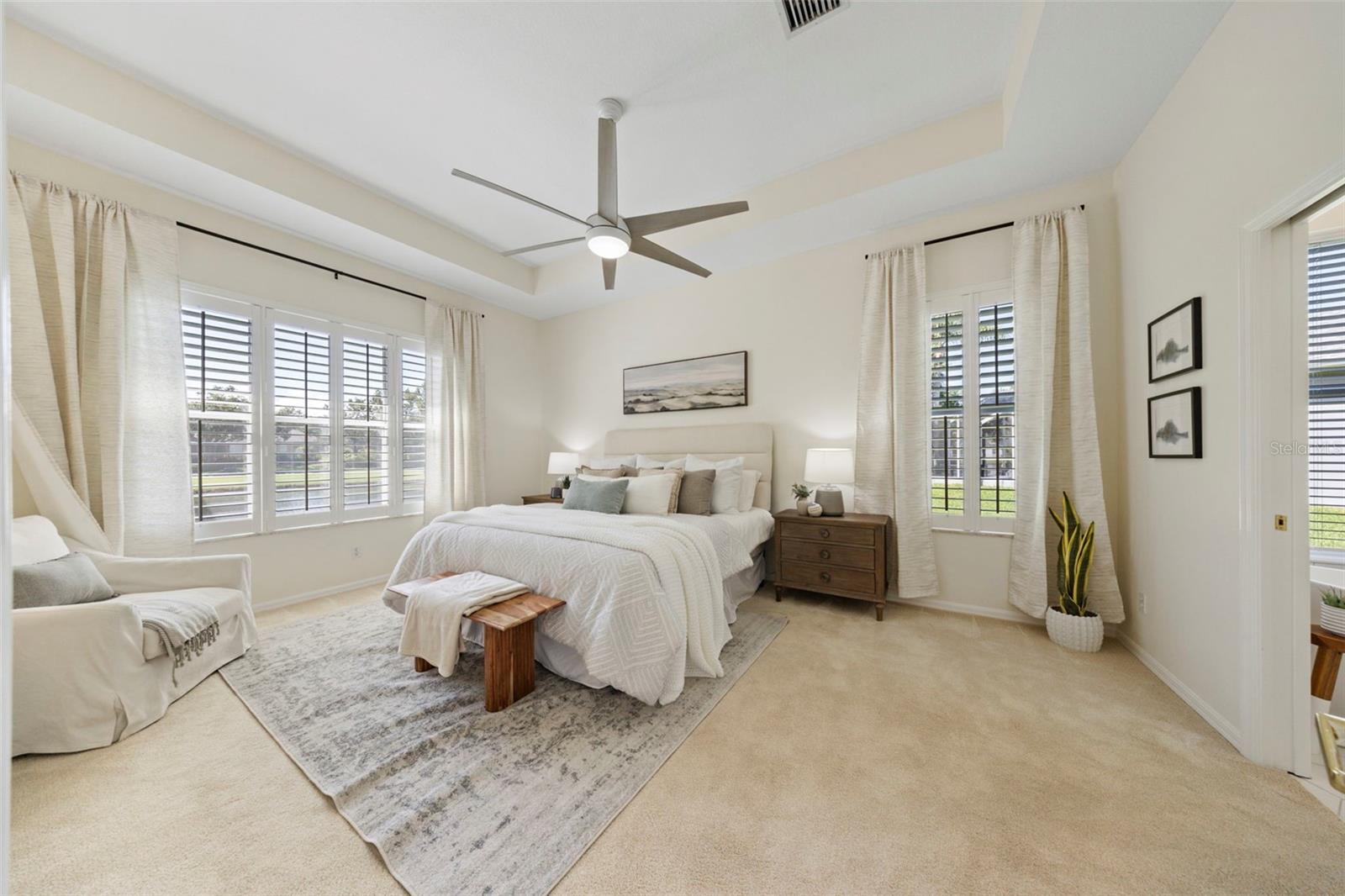 Spacious primary suite overlooking pool and pond.