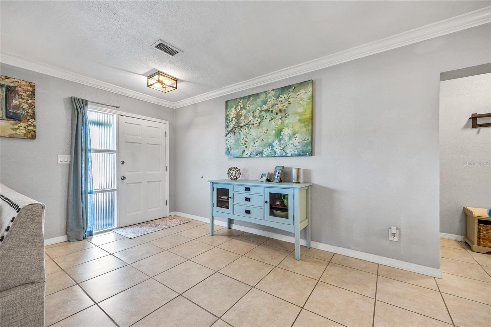 Bright, welcoming entry with clean lines, crown molding, and space to make a stylish first impression.