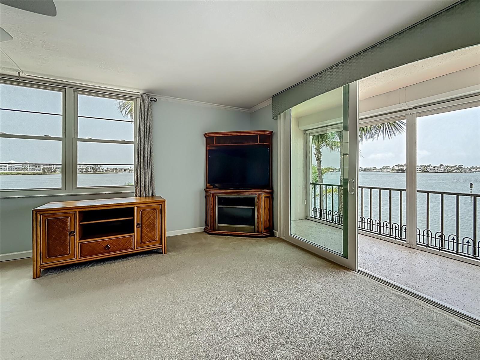 Updated sliders lead out to your balcony.  Notice the corner unit piece that does convey with a fireplace and television.