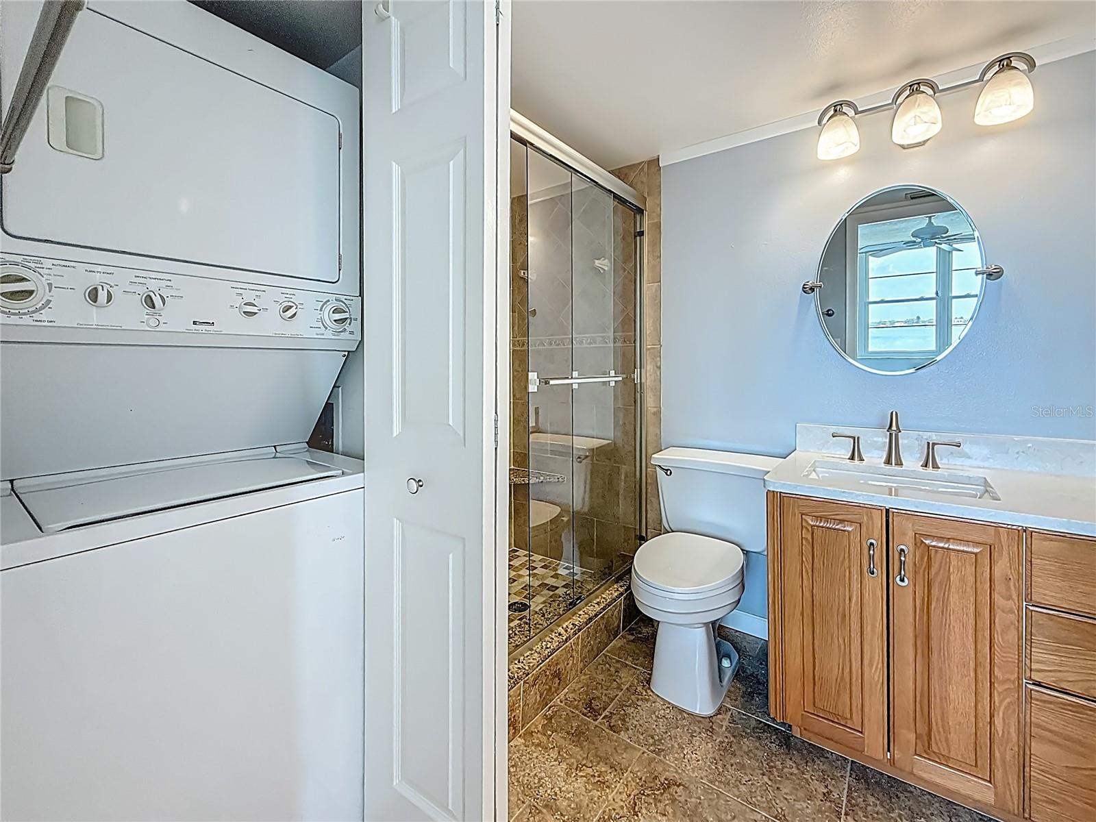 The stackable washer and dryer are located in a closet right off the primary bedroom as you enter the primary bathroom.