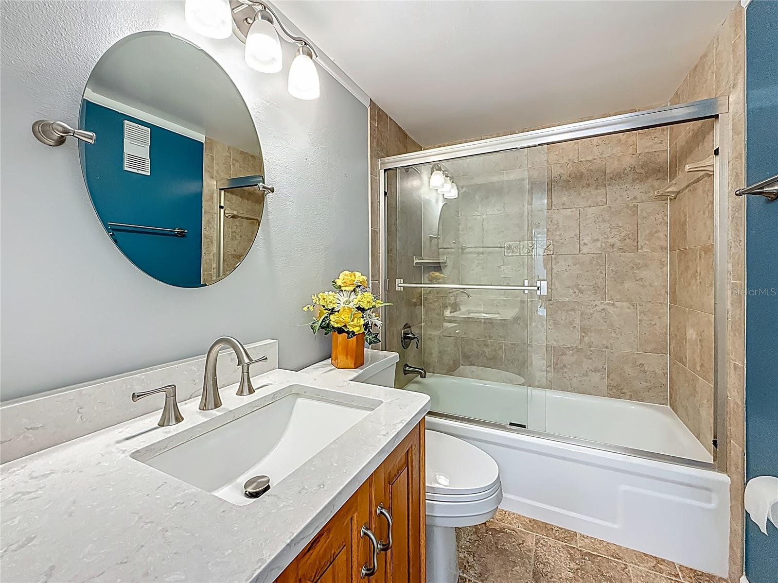 Updated Guest bathroom with higher height vanity, stone counter top and tub with shower.