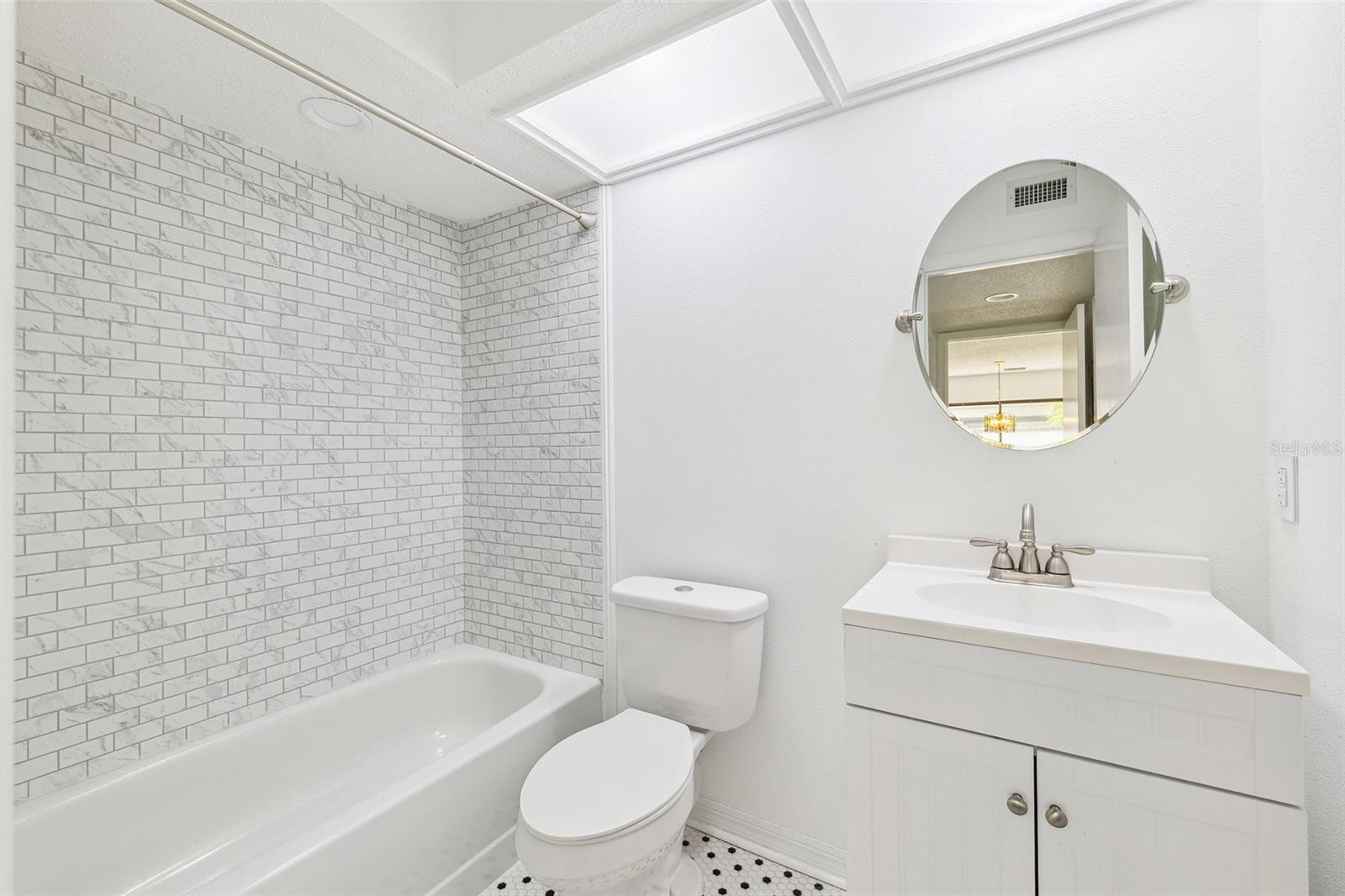 Downstairs bathroom, next to laundry area and across from a downstairs bedroom.