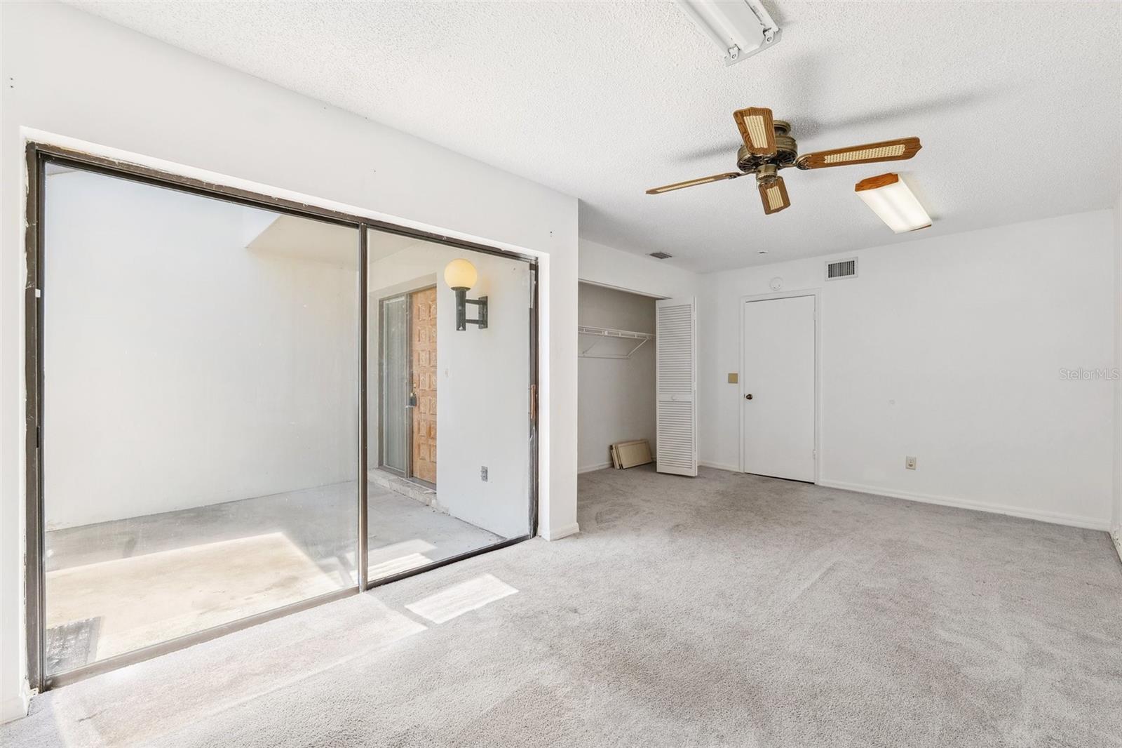 Secondary bedroom downstair with slider out to the front yard area.