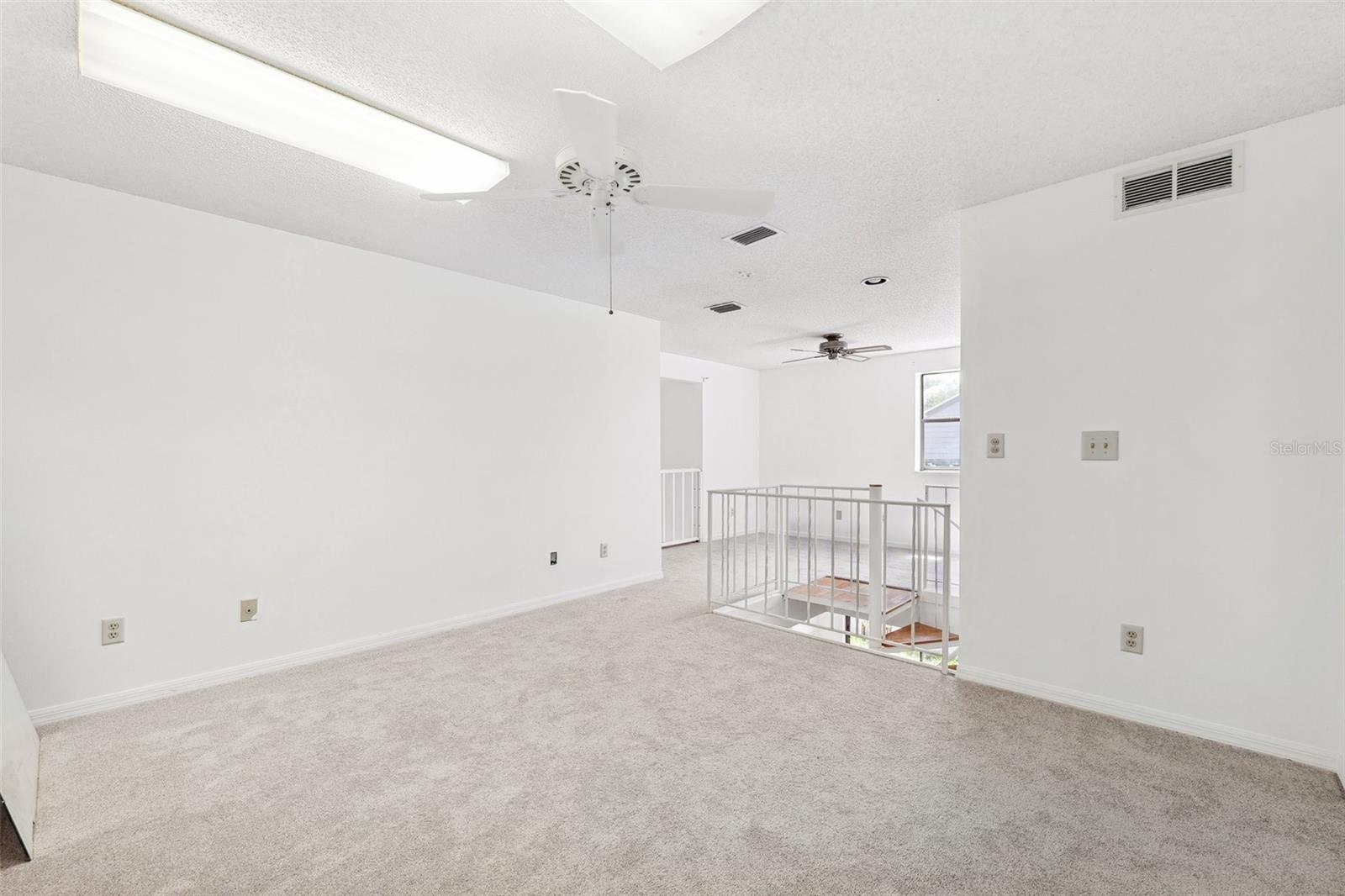 Loft style bedroom upstairs with extra space near the window ideal for an office area.