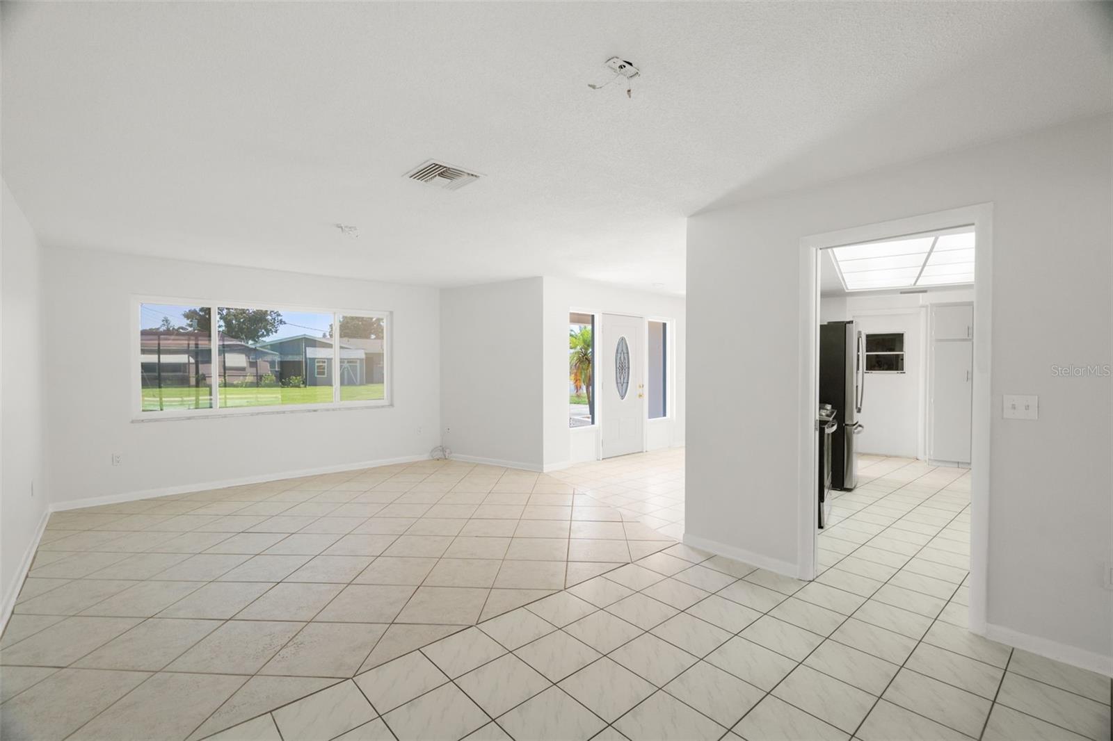 front door view of living room/dining area combo, leads into the kitchen