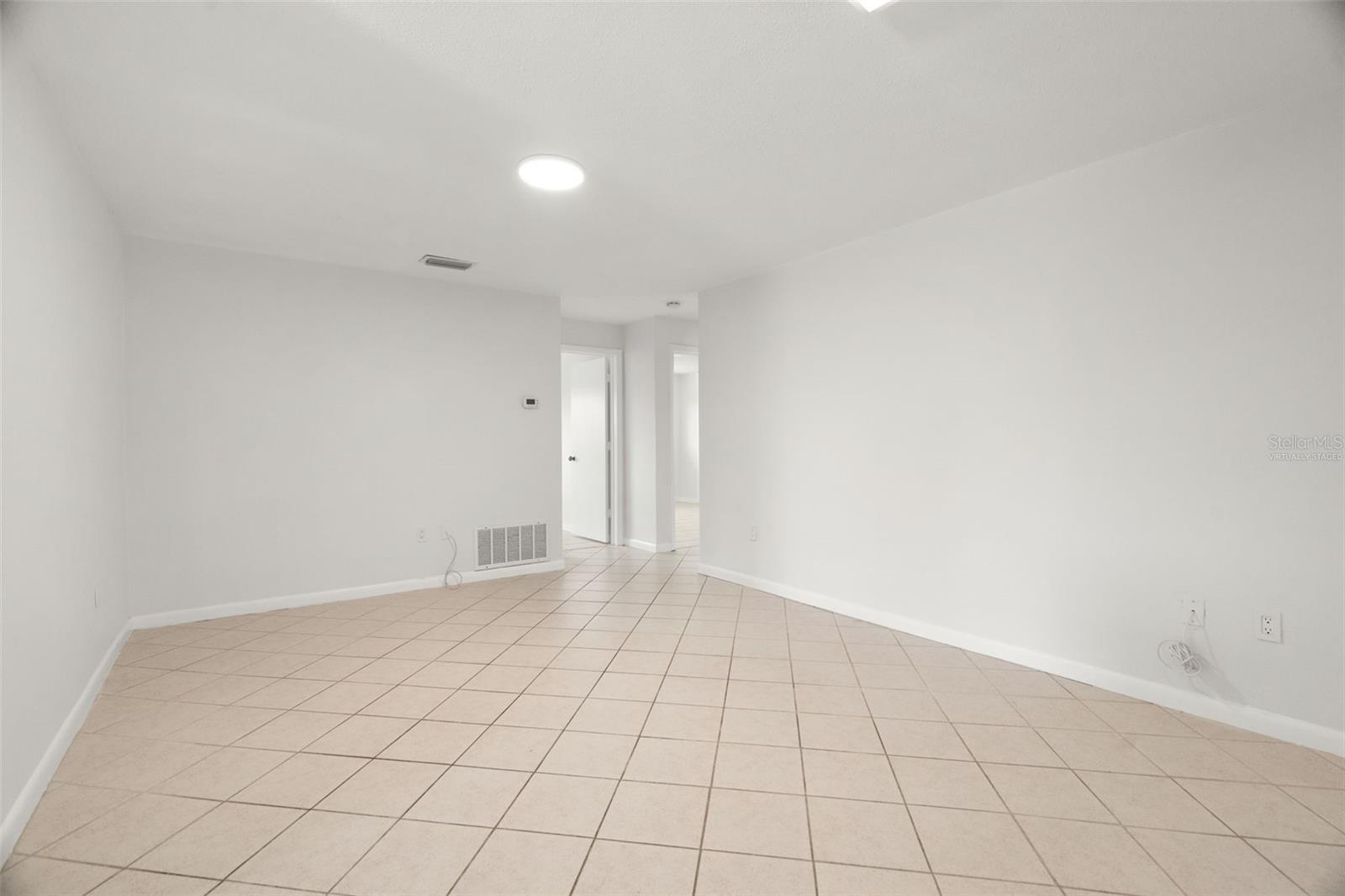 virtually staged additional living or dining room space after you go through the kitchen