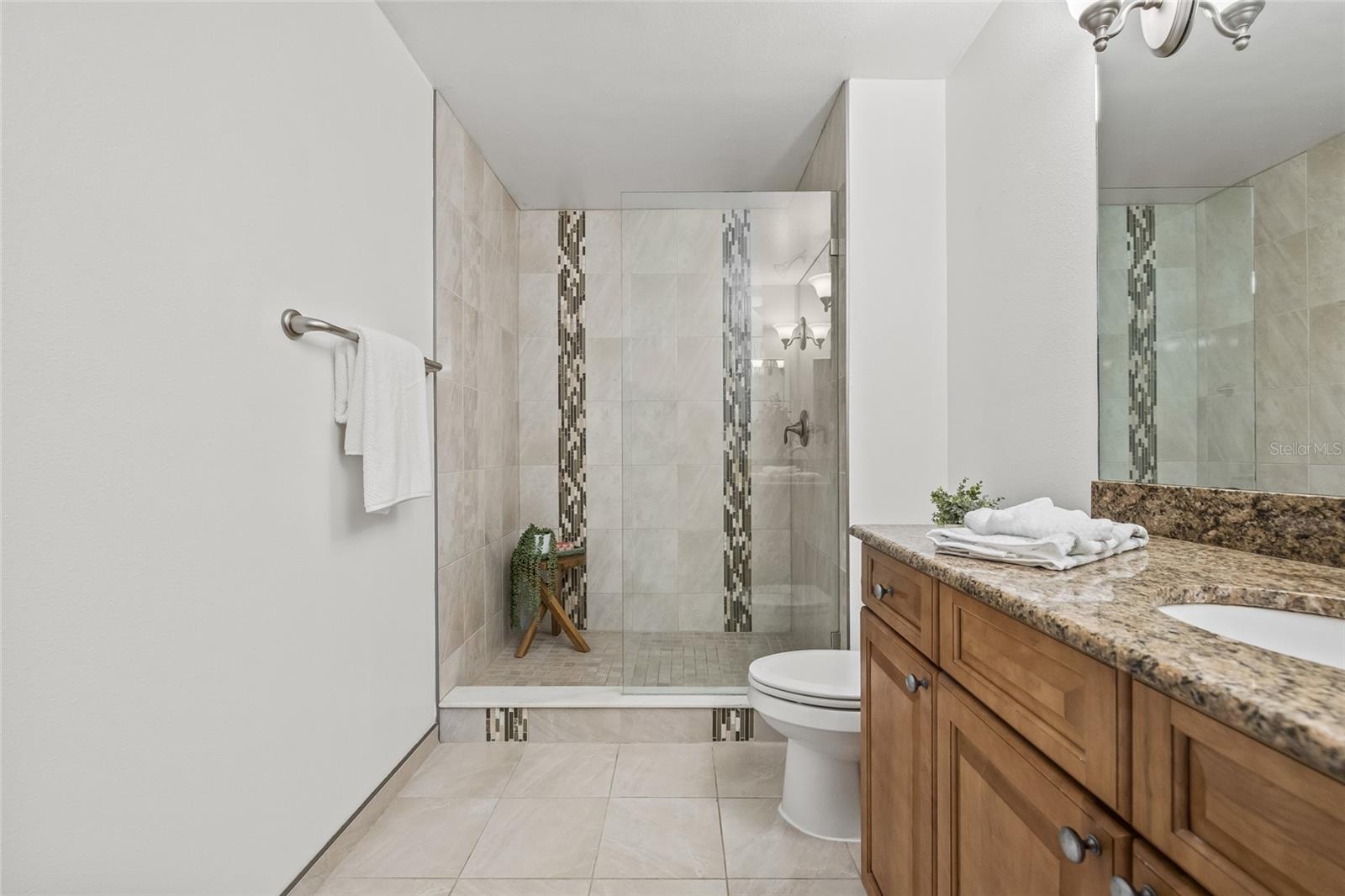 Spa-Inspired Walk-In Shower. The oversized glass-enclosed shower with mosaic tile accents brings a touch of luxury to your daily routine.