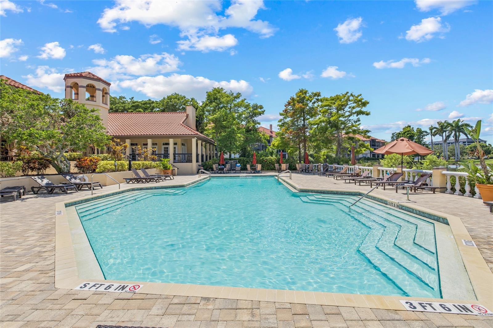 Community Pool with Clubhouse. Resort-style pool surrounded by lush landscaping and a charming clubhouse—perfect for relaxation and socializing.