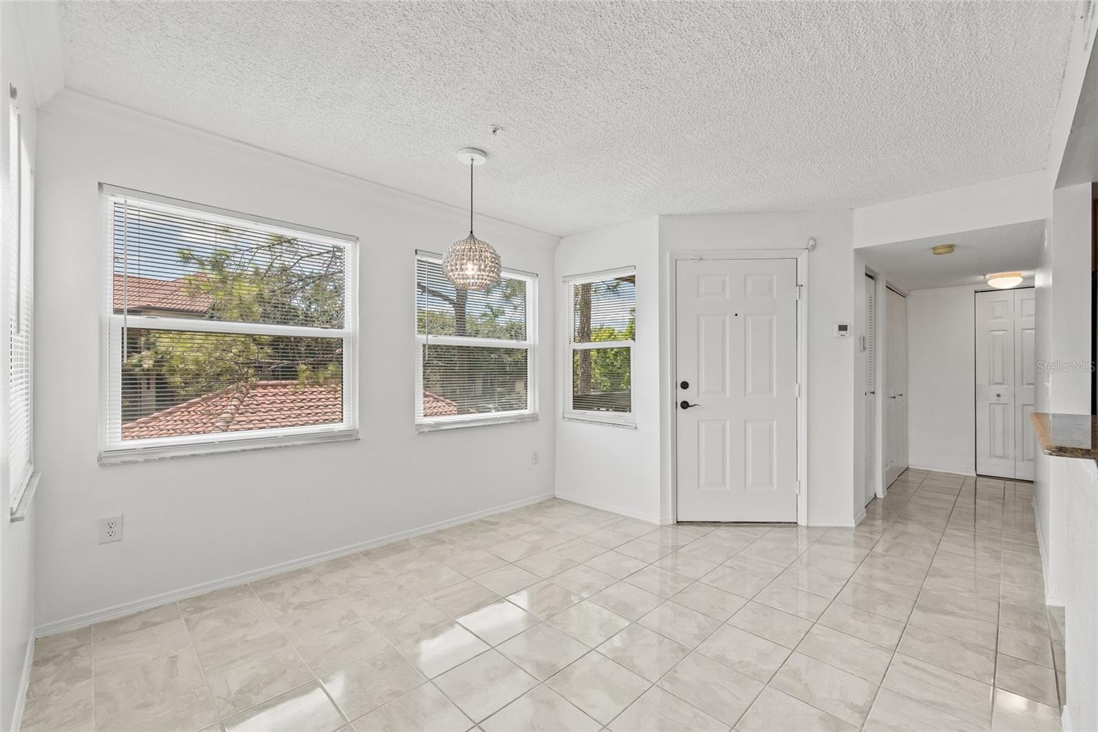 Sunny Dining Nook with Neighborhood Views. A charming light fixture and large windows make this corner the ideal spot for casual meals or a cozy reading area.