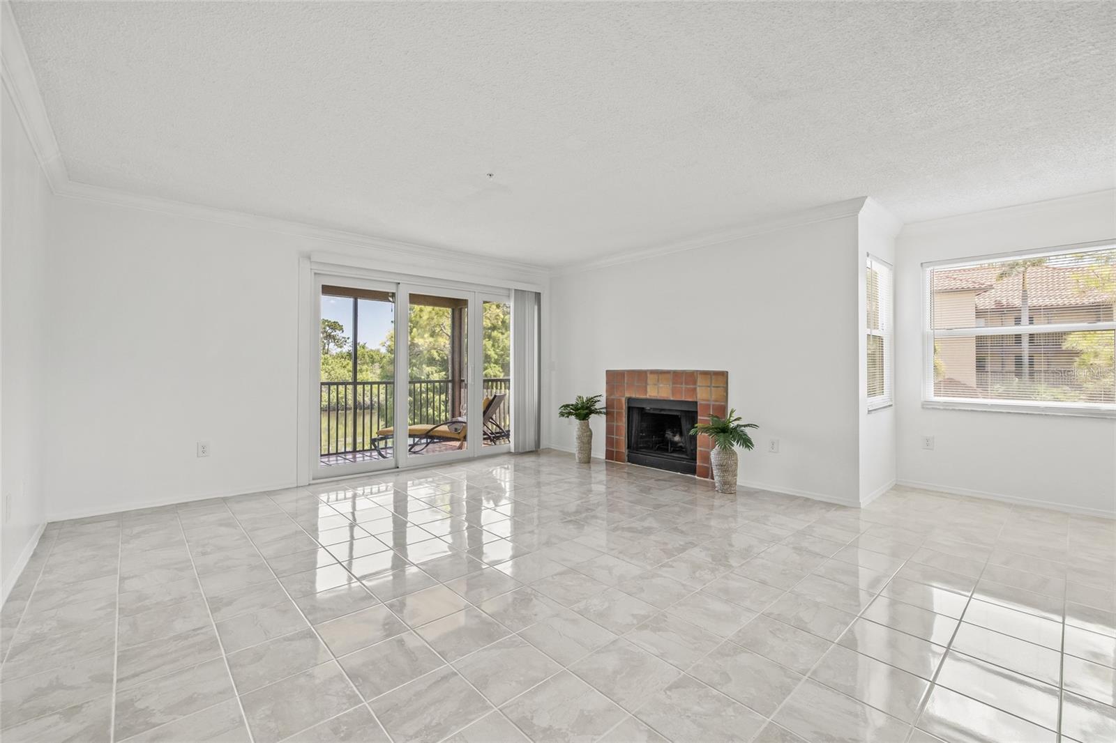 Living Room with Fireplace and Lanai Access. Gather around the cozy fireplace or step out to the lanai from this versatile and welcoming living area.
