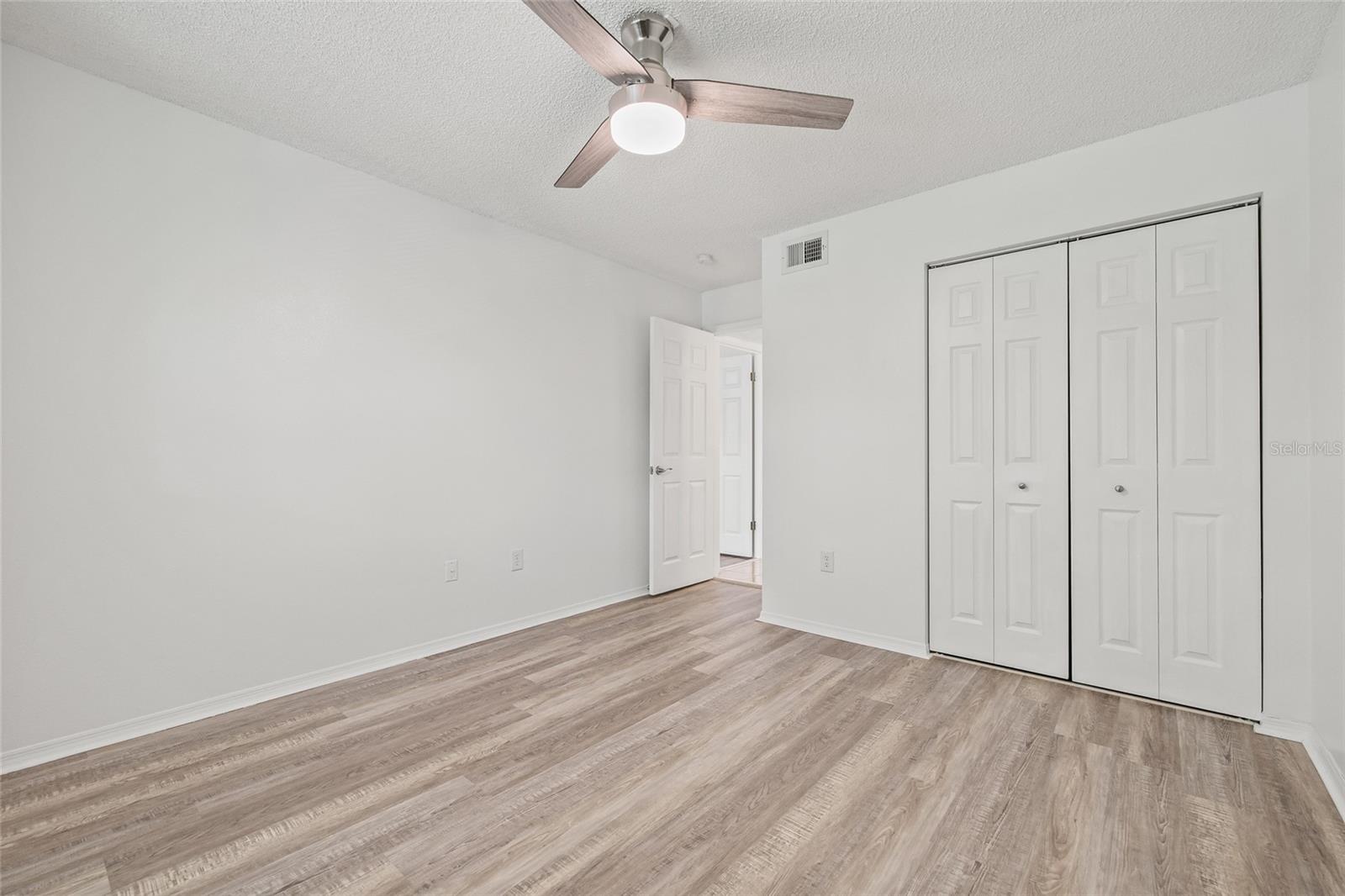 Guest Bedroom with Ample Storage. Includes a generous closet, ceiling fan, and plenty of natural light—perfect for visitors or a home office.