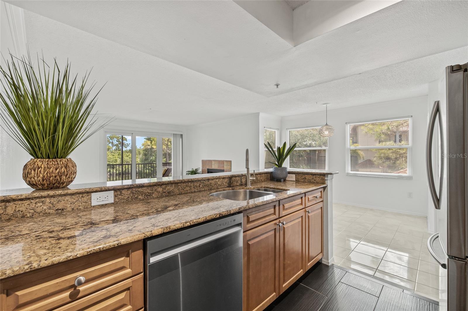 Open Kitchen with Granite Breakfast Bar. Enjoy seamless flow from the kitchen into the bright living space, perfect for entertaining or relaxing at home.