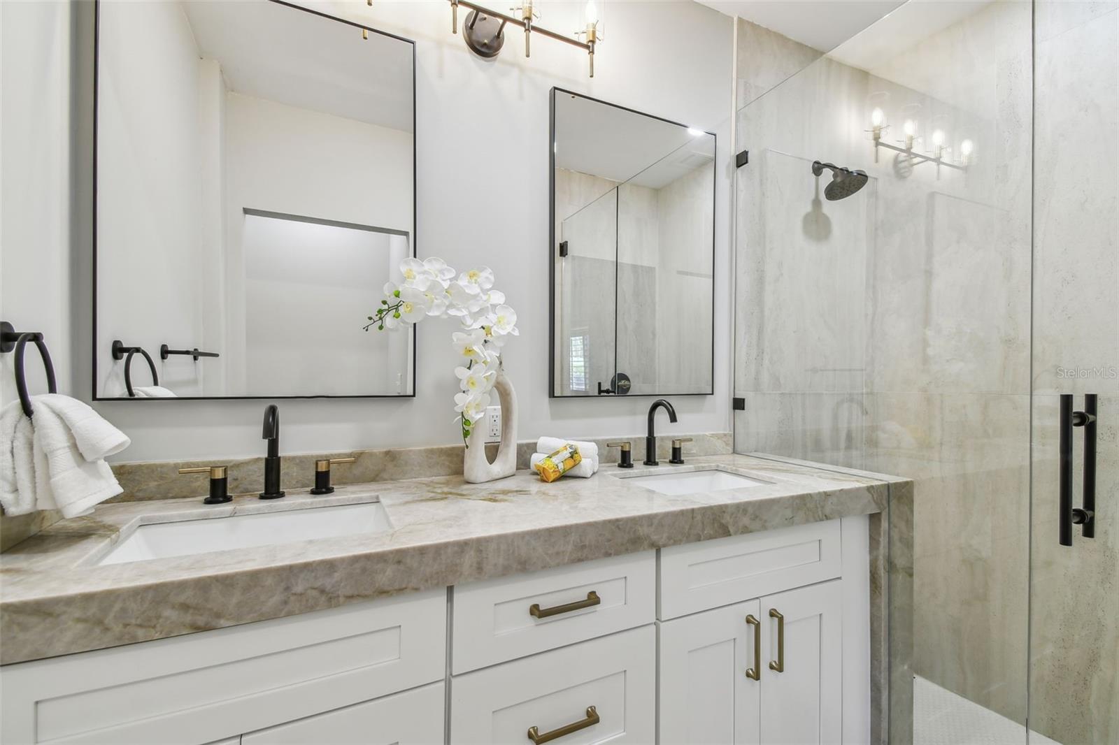 Taj Majal Quartzite counters with a waterfall edge allow for a shelf in the shower and add a luxury touch and feel!